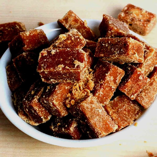 Organic jaggery cubes in white bowl